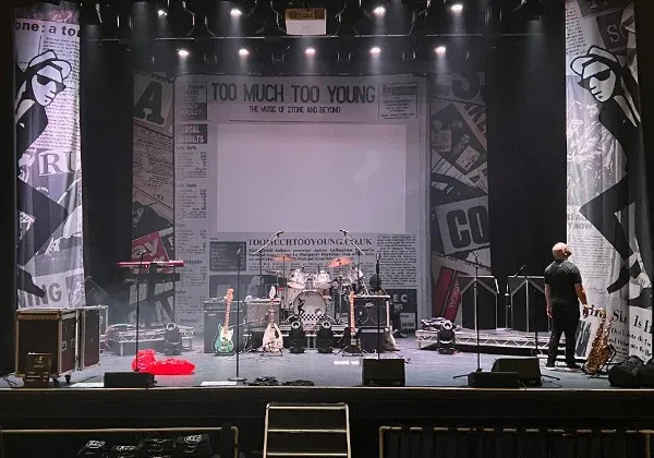 Image of stage banners for Too Much Too Young